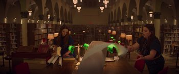Movie still from “Booksmart” (2019), directed by Olivia Wilde – A woman sitting at a table in a library; Medium shot, High angle