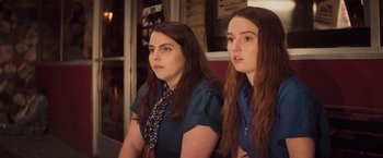Movie still from “Booksmart” (2019), directed by Olivia Wilde – Two young women sitting next to each other in front of a window; Close Up shot, Over the shoulder angle