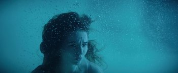 Movie still from “Booksmart” (2019), directed by Olivia Wilde – A woman in the water with her hair blowing in the wind; Close Up shot, Overhead angle