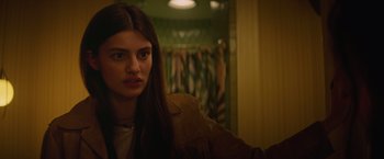 Movie still from “Booksmart” (2019), directed by Olivia Wilde – A woman in a brown jacket is looking at the camera; Close Up shot, Over the shoulder angle