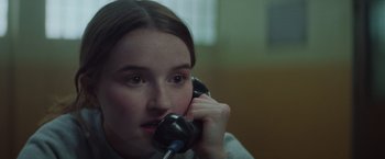 Movie still from “Booksmart” (2019), directed by Olivia Wilde – A woman talking on a phone while sitting in a room; Close Up shot, Over the shoulder angle