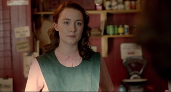 Movie still from “Brooklyn” (2015), directed by John Crowley – A woman with long red curly hair wearing a green dress; Medium shot, Over the shoulder angle