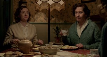 Movie still from “Brooklyn” (2015), directed by John Crowley – Two women sitting at a dinner table with a teapot; Medium shot, High angle