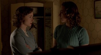 Movie still from “Brooklyn” (2015), directed by John Crowley – Two women standing next to each other in front of a door; Medium shot, Over the shoulder angle