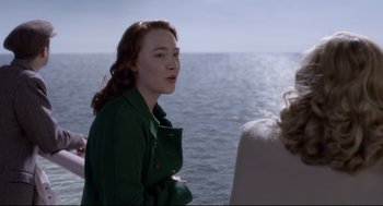Movie still from “Brooklyn” (2015), directed by John Crowley – A woman in a green jacket looking out at the ocean; Medium shot, Over the shoulder angle