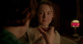 Movie still from “Brooklyn” (2015), directed by John Crowley – A woman holding a wine glass in front of a mirror; Close Up shot, Over the shoulder angle