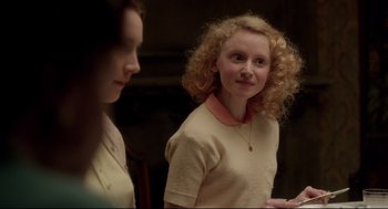 Movie still from “Brooklyn” (2015), directed by John Crowley – Two young women standing next to each other in a room; Medium shot, Over the shoulder angle