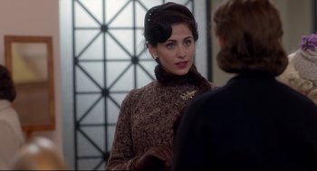 Movie still from “Brooklyn” (2015), directed by John Crowley – A woman in a brown dress talking to a man; Close Up shot, Over the shoulder angle