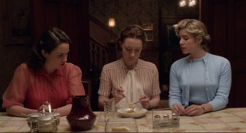Movie still from “Brooklyn” (2015), directed by John Crowley – A group of people sitting at a table eating food; Medium shot, High angle