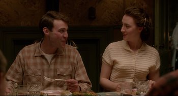 Movie still from “Brooklyn” (2015), directed by John Crowley – A man and a woman sitting at a dinner table; Medium shot, Over the shoulder angle