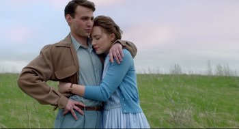 Movie still from “Brooklyn” (2015), directed by John Crowley – A man and a woman hugging in a field; Medium shot, Over the shoulder angle
