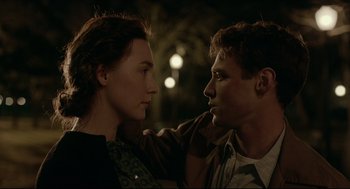 Movie still from “Brooklyn” (2015), directed by John Crowley – A man and a woman standing next to each other; Close Up shot, Over the shoulder angle