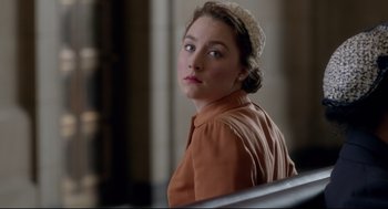 Movie still from “Brooklyn” (2015), directed by John Crowley – A woman in a brown shirt and a white hat; Close Up shot, Over the shoulder angle