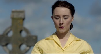 Movie still from “Brooklyn” (2015), directed by John Crowley – A woman in a yellow shirt is looking down at her face; Close Up shot, Over the shoulder angle