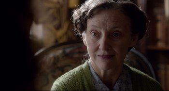 Movie still from “Brooklyn” (2015), directed by John Crowley – An older woman wearing a green sweater looking at the camera; Close Up shot, Over the shoulder angle