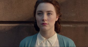 Movie still from “Brooklyn” (2015), directed by John Crowley – A young woman wearing a white shirt and a blue sweater; Close Up shot, Over the shoulder angle