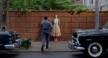Movie still from “Brooklyn” (2015), directed by John Crowley – A man and a woman standing in front of a brick wall; Wide shot, Over the shoulder angle