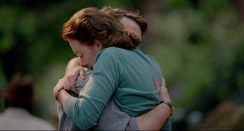 Movie still from “Brooklyn” (2015), directed by John Crowley – A man and a woman hugging each other; Medium shot, Over the shoulder angle