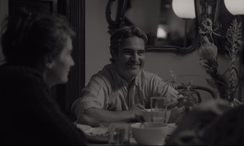 Movie still from “C'mon C'mon” (2021), directed by Mike Mills – A man sitting at a dinner table with a woman; Close Up shot, Over the shoulder angle