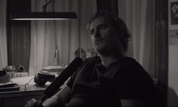 Movie still from “C'mon C'mon” (2021), directed by Mike Mills – A black and white photo of a man sitting in front of a lamp; Close Up shot, Over the shoulder angle