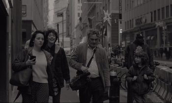 Movie still from “C'mon C'mon” (2021), directed by Mike Mills – A group of people walking down a street; Medium shot, Over the shoulder angle