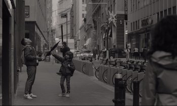 Movie still from “C'mon C'mon” (2021), directed by Mike Mills – A young child holding a umbrella on a city street; Medium shot, Over the shoulder angle
