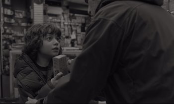 Movie still from “C'mon C'mon” (2021), directed by Mike Mills – A young boy is holding a box in his hands; Medium shot, Over the shoulder angle
