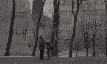 Movie still from “C'mon C'mon” (2021), directed by Mike Mills – A man and a child standing next to a tree in a park; Extreme Wide shot, High angle
