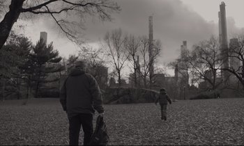 Movie still from “C'mon C'mon” (2021), directed by Mike Mills – A man and a child walking through a park; Wide shot, Low angle