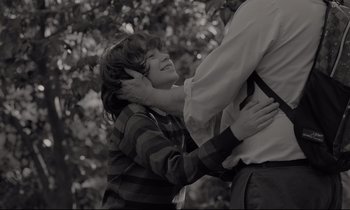 Movie still from “C'mon C'mon” (2021), directed by Mike Mills – A young boy is hugging an older man; Medium shot, Over the shoulder angle