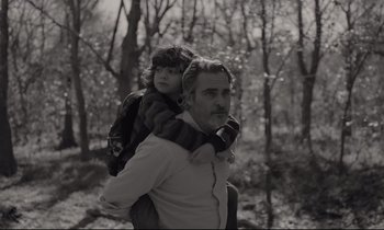 Movie still from “C'mon C'mon” (2021), directed by Mike Mills – A black and white photo of a man carrying a little girl; Medium shot, Low angle