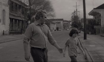 Movie still from “C'mon C'mon” (2021), directed by Mike Mills – An older man and young girl walking down a street; Medium shot, Over the shoulder angle
