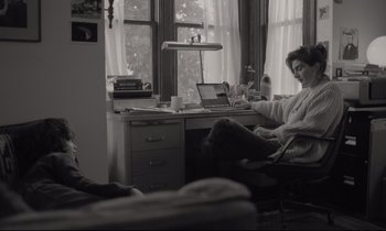 Movie still from “C'mon C'mon” (2021), directed by Mike Mills – A woman sitting in front of a computer desk in a room; Medium shot, High angle