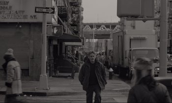 Movie still from “C'mon C'mon” (2021), directed by Mike Mills – A man is walking down the street in the city; Wide shot, Over the shoulder angle