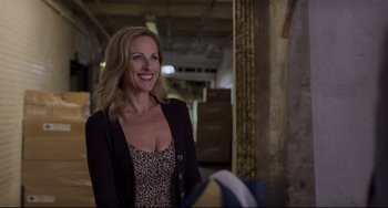 Movie still from “CODA” (2021), directed by Sian Heder – A woman in a leopard print dress smiling; Medium shot, Over the shoulder angle