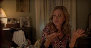 Movie still from “CODA” (2021), directed by Sian Heder – A woman sitting in front of a window with her hands raised; Close Up shot, Over the shoulder angle