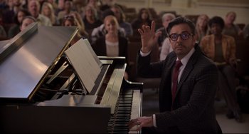 Movie still from “CODA” (2021), directed by Sian Heder – A man in a suit and tie sitting at a grand piano; Medium shot, Over the shoulder angle