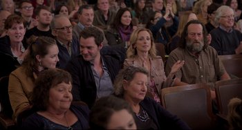 Movie still from “CODA” (2021), directed by Sian Heder – A group of people sitting and standing in a room; Medium shot, Over the shoulder angle