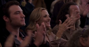 Movie still from “CODA” (2021), directed by Sian Heder – A group of people clapping and smiling at an event; Medium shot, Over the shoulder angle