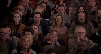 Movie still from “CODA” (2021), directed by Sian Heder – A group of people sitting and clapping in a room; Medium shot, Over the shoulder angle