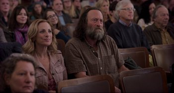 Movie still from “CODA” (2021), directed by Sian Heder – A man and a woman are sitting in a row of seats; Medium shot, Over the shoulder angle