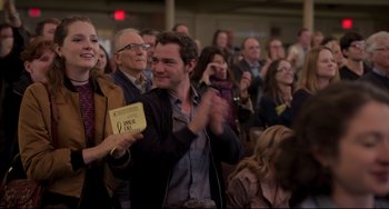 Movie still from “CODA” (2021), directed by Sian Heder – A man is clapping in front of a group of people; Medium shot, Over the shoulder angle