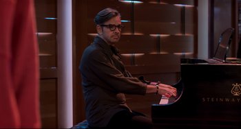 Movie still from “CODA” (2021), directed by Sian Heder – A man sitting at a piano in front of a window; Medium shot, High angle