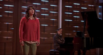 Movie still from “CODA” (2021), directed by Sian Heder – A woman standing in front of a man sitting at a piano; Medium shot, Over the shoulder angle
