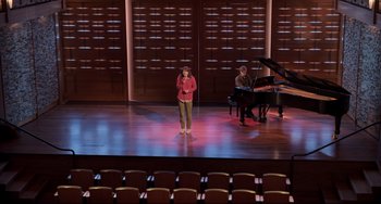 Movie still from “CODA” (2021), directed by Sian Heder – A woman standing on a stage with a microphone; Extreme Wide shot, High angle