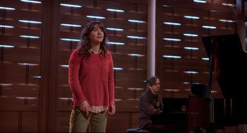 Movie still from “CODA” (2021), directed by Sian Heder – A woman standing in front of a piano in front of a man; Medium shot, Over the shoulder angle