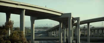 An overpass with a view of a city skyline in the distance