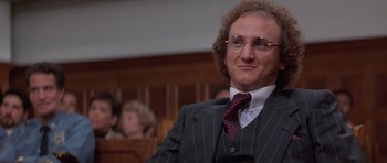 Movie still from “Carlito's Way” (1993), directed by Brian De Palma – A man in a suit and tie sitting in a courtroom; Close Up shot, Low angle