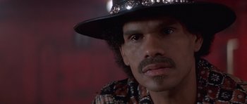 Movie still from “Carlito's Way” (1993), directed by Brian De Palma – A person wearing a hat and looking at the camera; Close Up shot, Low angle