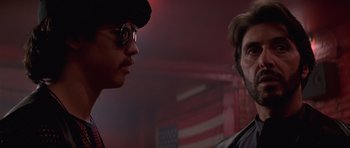 Movie still from “Carlito's Way” (1993), directed by Brian De Palma – A man and a woman standing next to each other in front of an american flag; Close Up shot, Low angle
